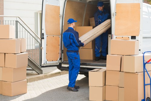 Removal team handling boxes with compliance paperwork in a warehouse