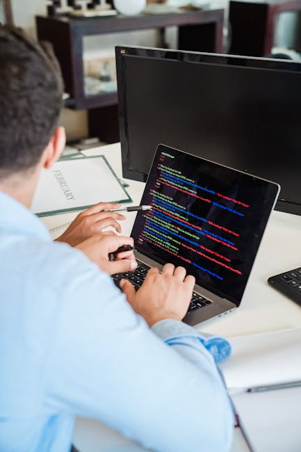 Close-up of a computer screen displaying colorful lines of programming code with syntax highlighting, featuring variables, functions, tags, and conditional statements. The code appears to be web devel